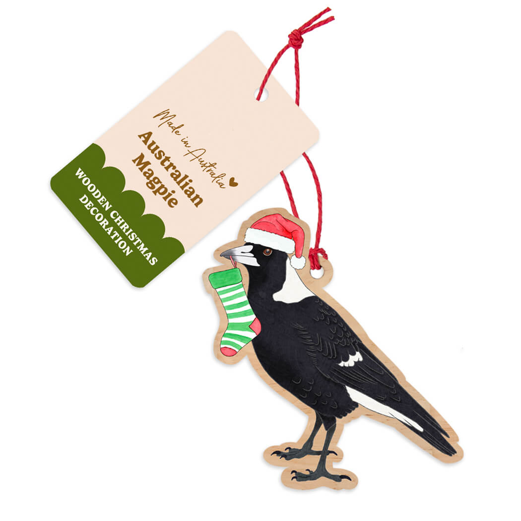 Australian made wooden magpie Christmas decoration wearing a Santa hat and holding a christmas stocking