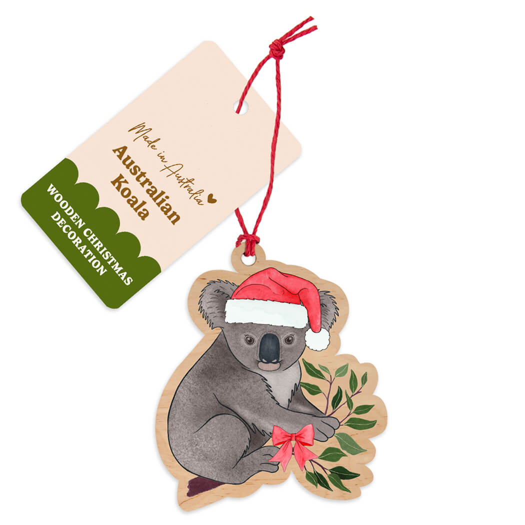 Australian made wooden koala Christmas decoration wearing a Santa hat and holding gum leaves