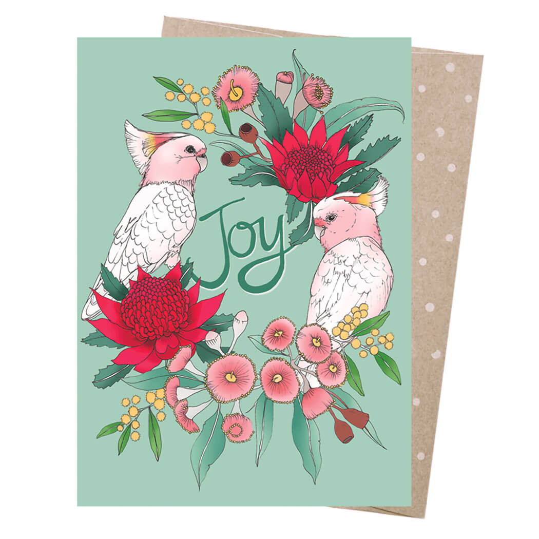 Australian made Christmas card with two pink cockatoos on a native flower wreath and Joy wording